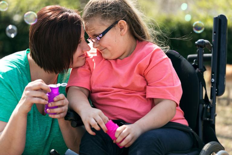 Adult female and young girl in a wheelchair