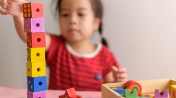 Foster child building a tower of blocks